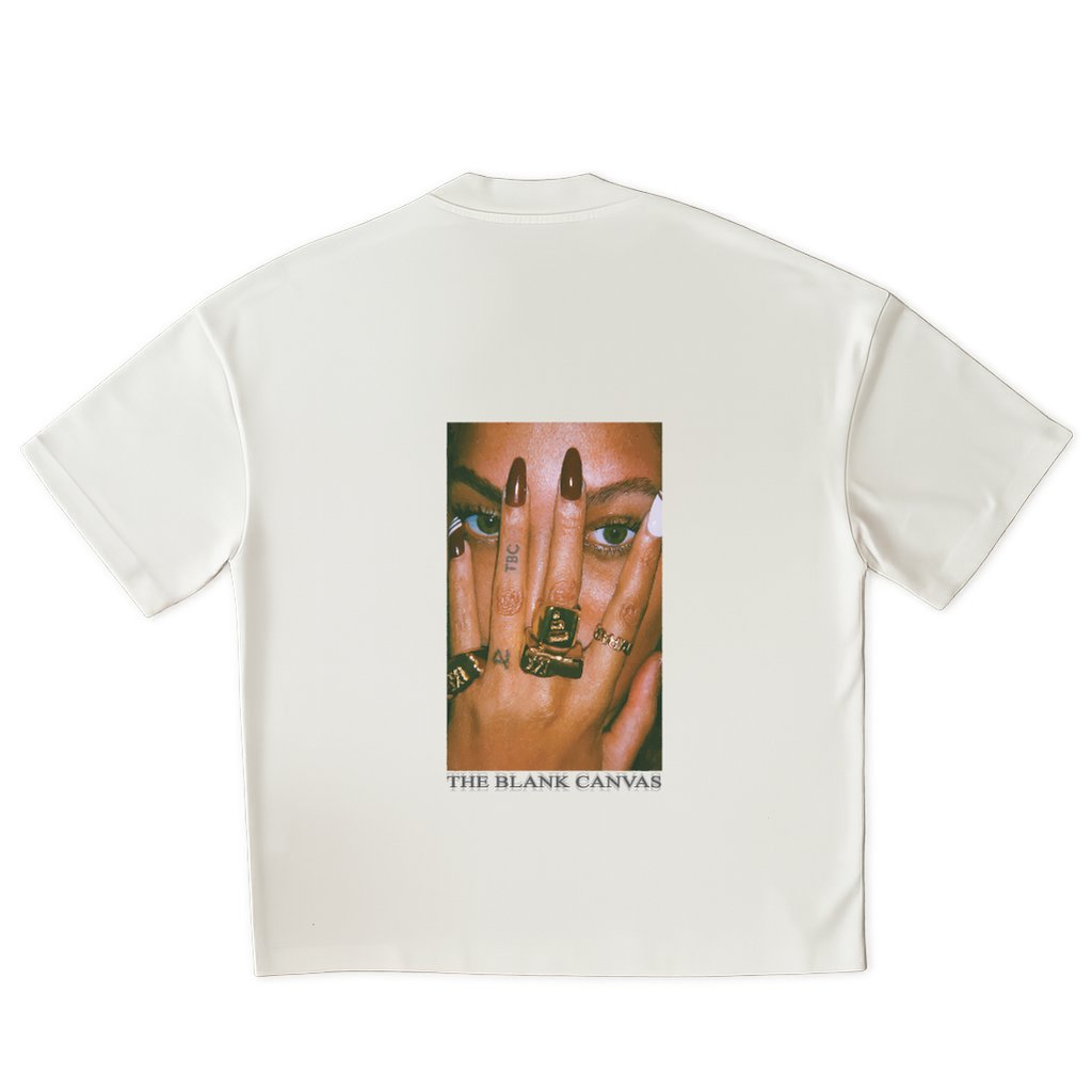 White t-shirt with a graphic of a face and hands on the back, featuring 'The Blank Canvas' brand.