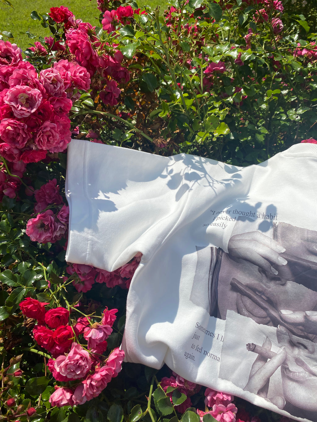 White shirt with graphic design on a background of pink flowers