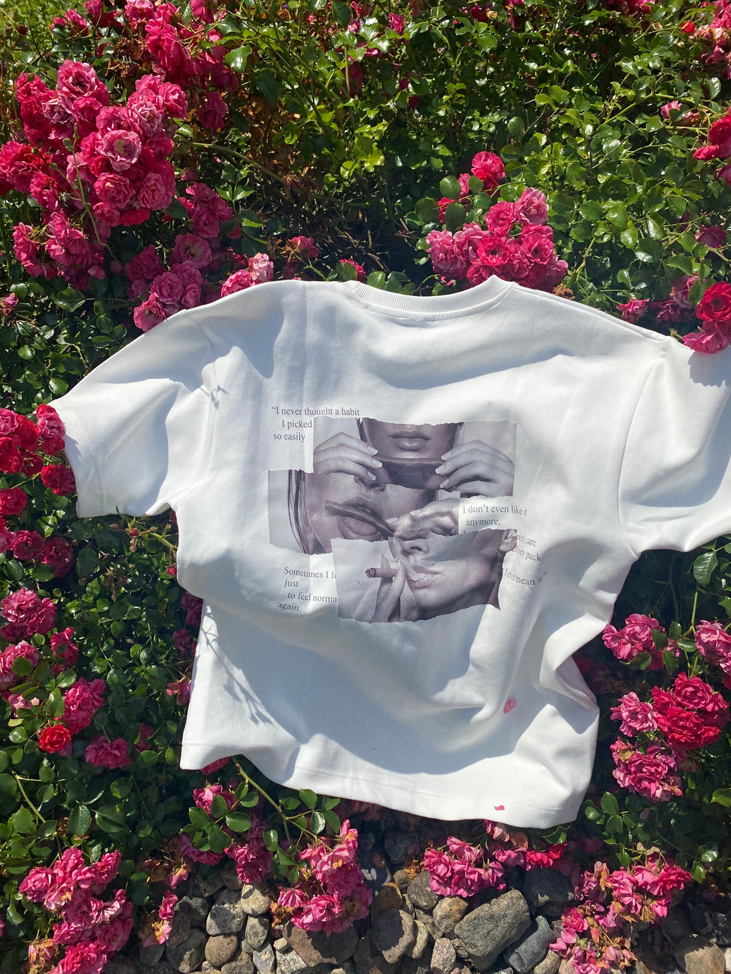 White shirt with printed design on a bed of pink flowers