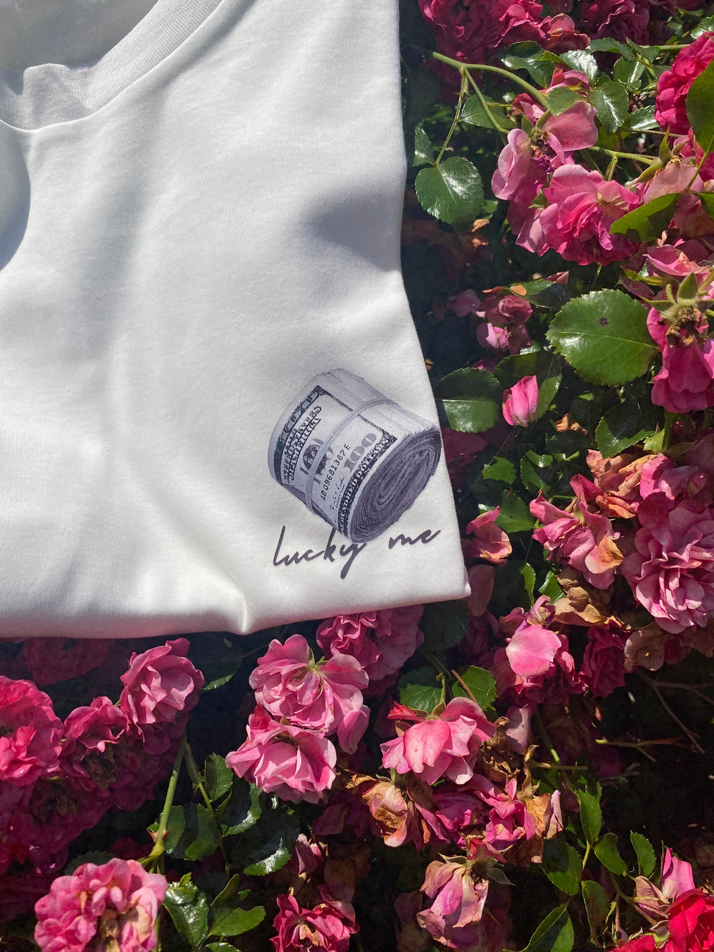 White garment with a label on a background of pink flowers