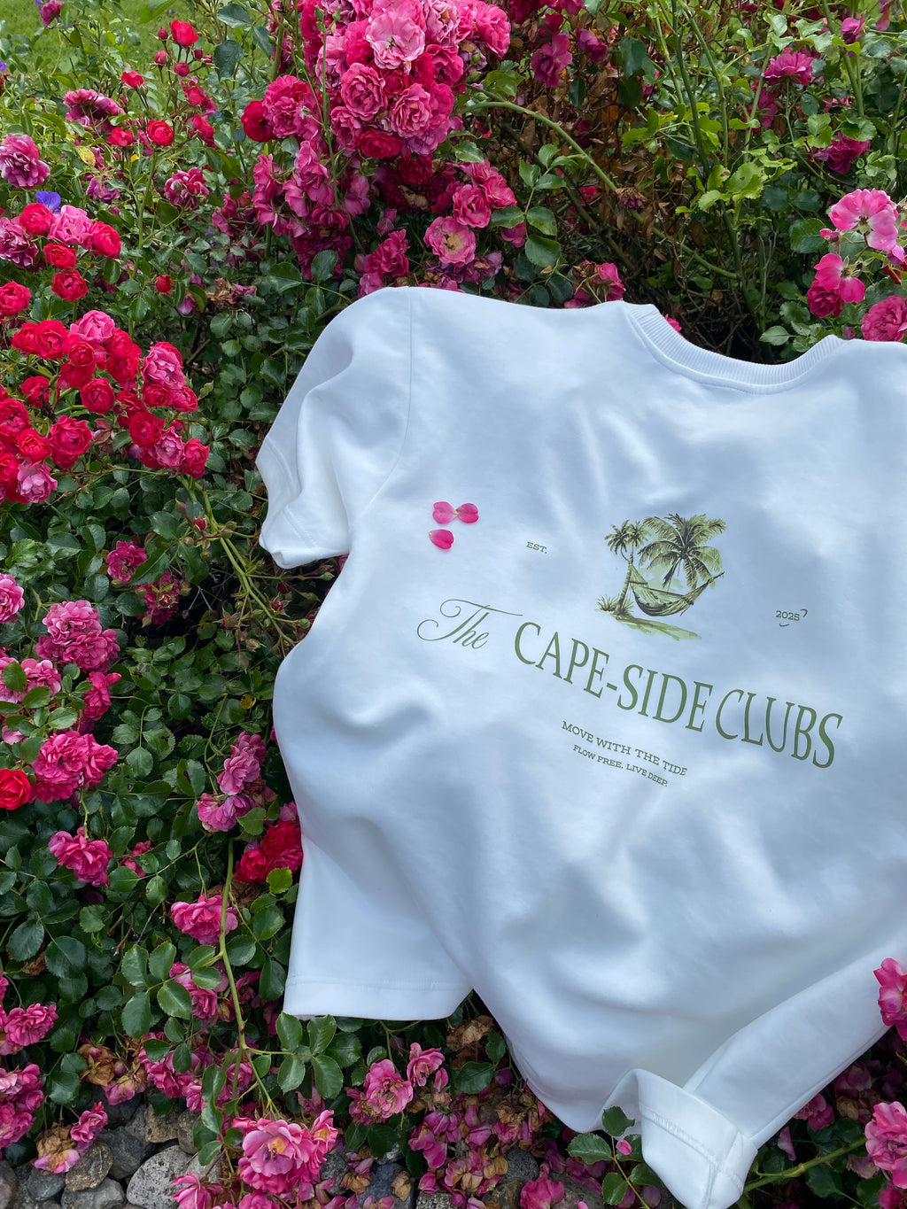 White top with text and logo on a bed of pink flowers